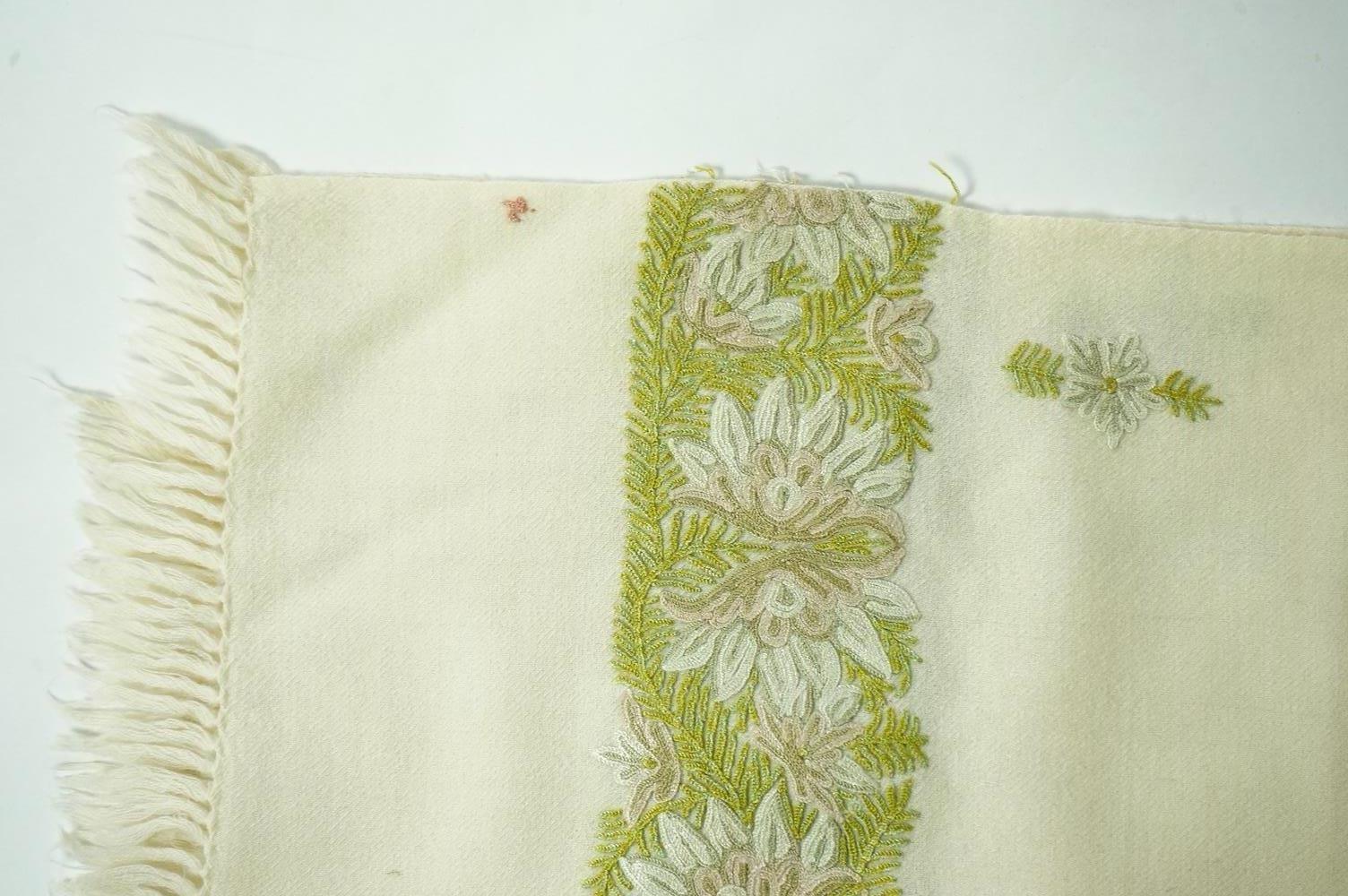 An Indian green and gold silk hand woven brocade stole, a cream pashmina embroidered stole and a similar finely woven and embroidered lilac stole (3). Brocade stole 38cm x 180cm., Condition - light stain to finely woven